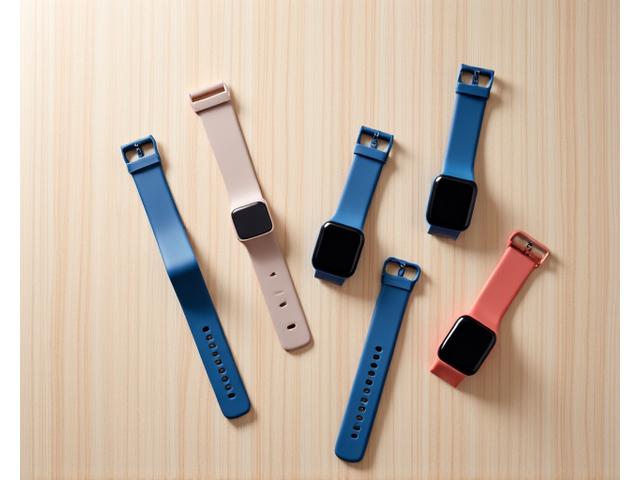 A diverse group of Fitbit devices (watches, trackers) laid out neatly, showcasing variety.
